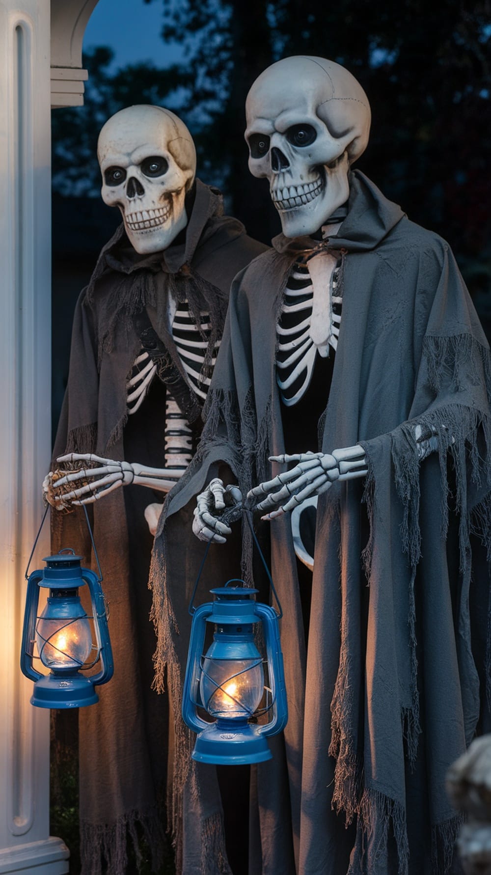 Two life-size skeletons in cloaks holding lanterns