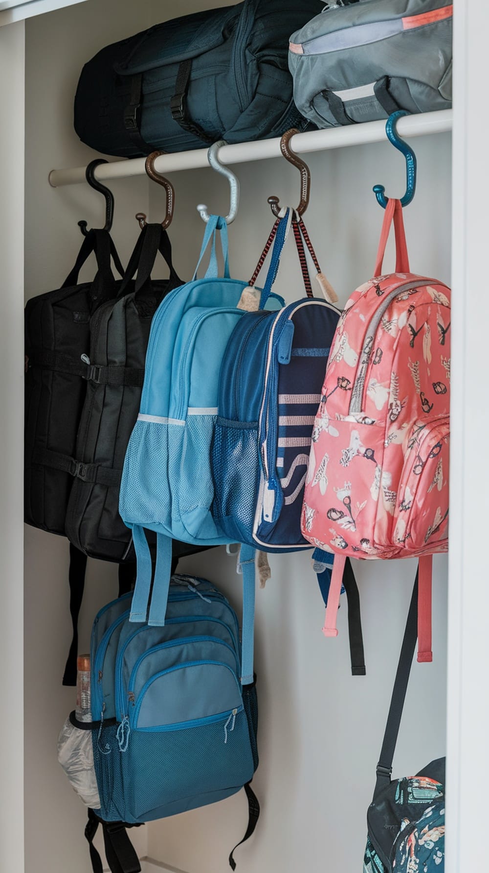 A coat closet featuring S-hooks with various bags and backpacks hanging neatly.