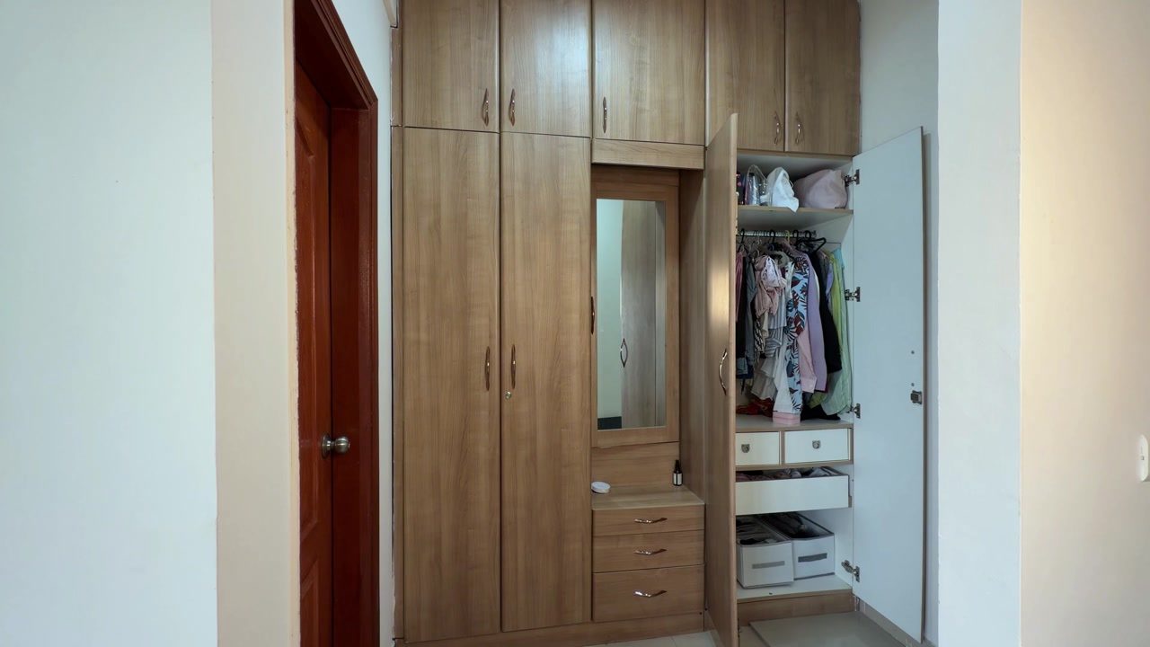 Open wardrobe with hanging clothes and shelf organizers arranged for easy access.
