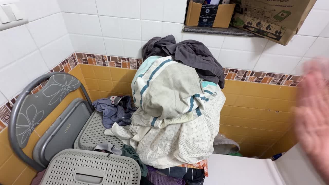 Overflowing laundry baskets crowding the floor in my tiny laundry room before the reset